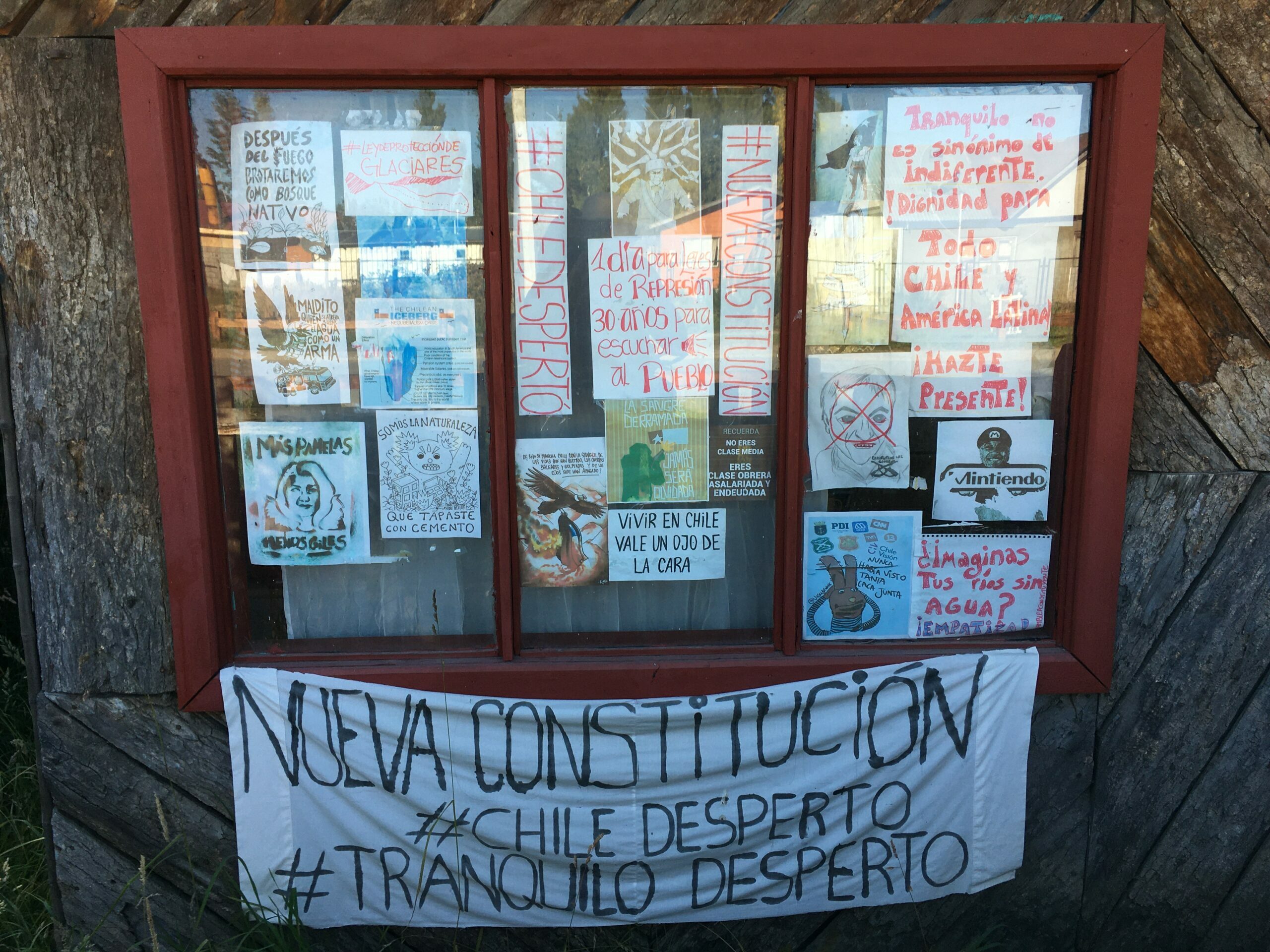 Frontis hogar en la región de Aysén con panfletos alusivos a la revuelta de octubre de 2019